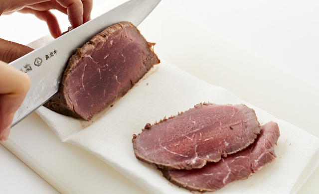 半解凍の状態のローストビーフをカットしている写真