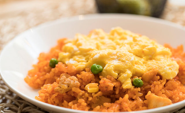 チキンライスの上にスクランブルエッグをのせた写真