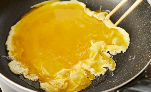 卵液を菜箸で混ぜている写真