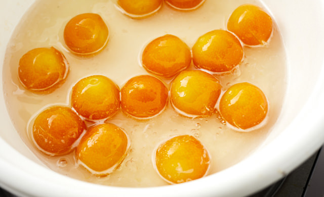 きんかんを鍋で煮詰めている写真