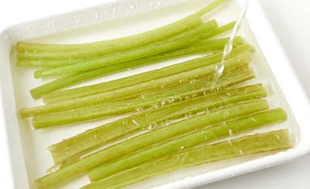 冷水を張ったバットでふきを冷やしている写真