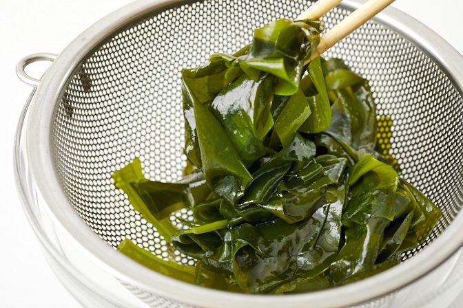 湯通しした生わかめをざるにあけた写真