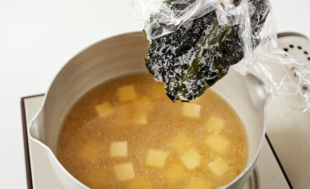 味噌汁に生わかめを加えている写真