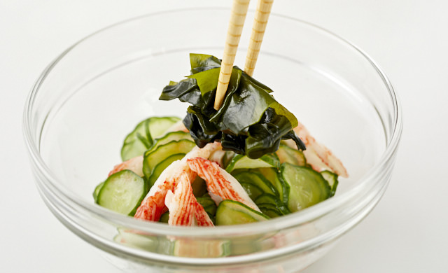酢の物に生わかめを加えている写真