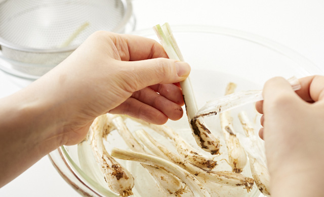 島らっきょうの薄皮をむいている写真