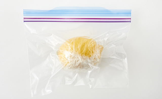 ラップで包んだレモンが冷凍用保存袋に入っている写真