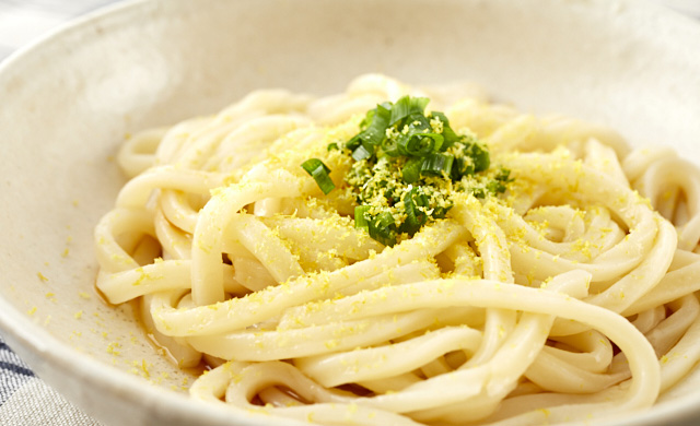 すりおろしたレモンがかかった冷やしうどんの写真