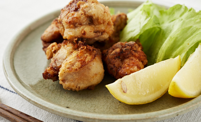 冷凍したくし形切りレモンを添えた唐揚げの写真