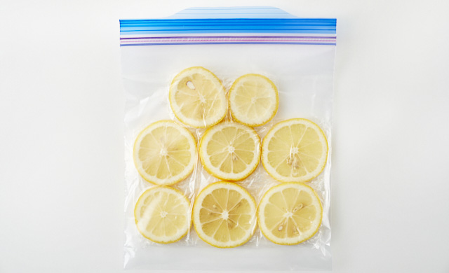 ラップで包んだ輪切りレモンが冷凍用保存袋に入っている写真