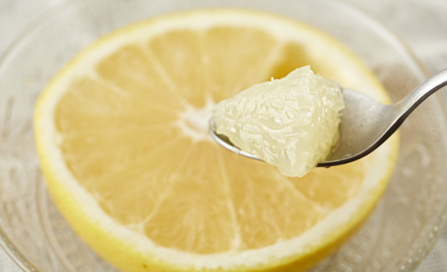 グレープフルーツをスプーンですくっている写真