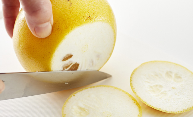 グレープフルーツの上下を切り落としている写真