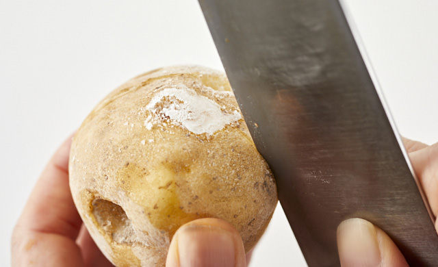 冷凍じゃがいもに切れ目を入れ、ゆでようとしている写真