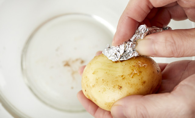 丸めたアルミホイルで新じゃがの皮をこする写真