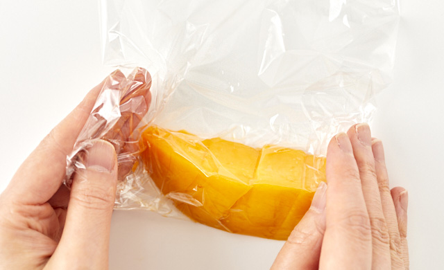 カットしたマンゴーをラップで包んでいる写真