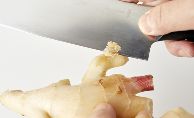 新生姜の硬い部分を切り取る写真