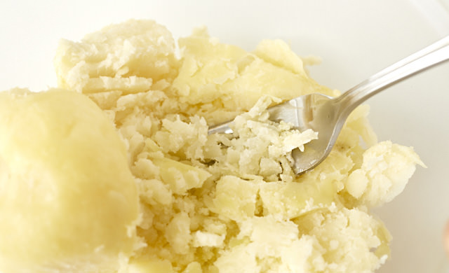 じゃがいもをフォークで潰している写真