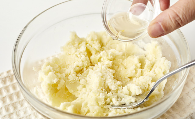 潰したじゃがいもに酢を加えている写真
