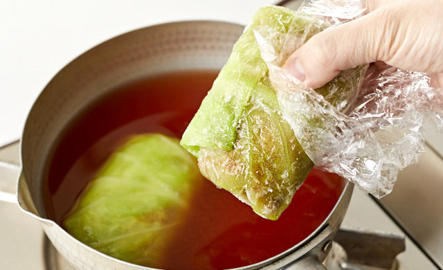 冷凍ロールキャベツを鍋に加えている写真