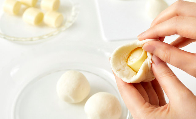 生地でチーズを包んでいる写真