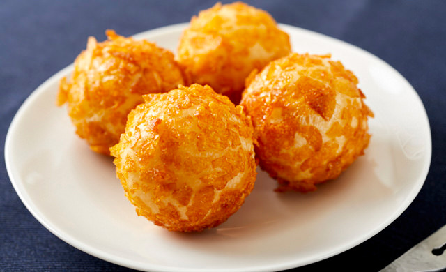砕いたコーンフレークをまぶして揚げたチーズボールの写真