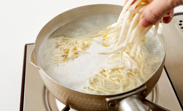 麺にもやしを加えている写真