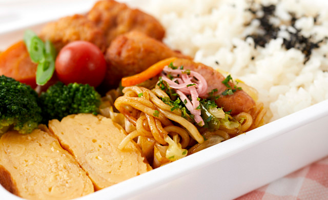 おかずカップをお弁当箱に入れている写真