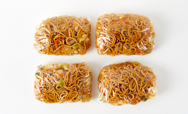 焼きそばを4つに分けてラップで包んでいる写真