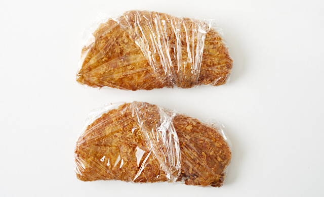 揚げたとんかつをラップで包んだ写真