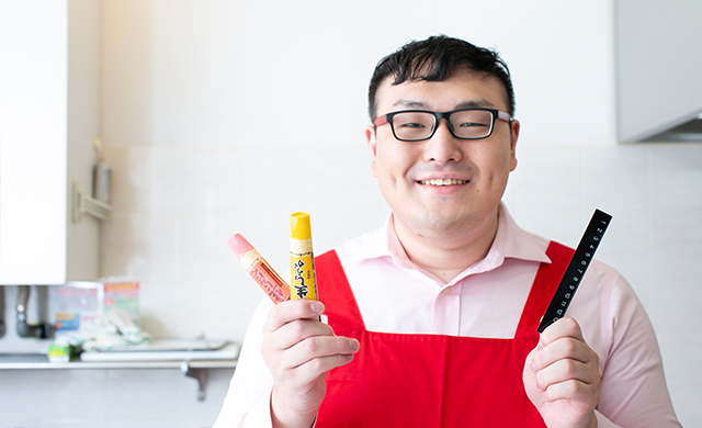 ジョーさん。がチューブの調味料と定規を手に持つ様子
