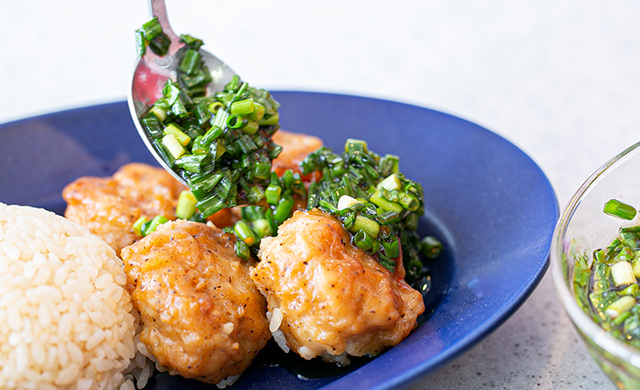 皿に盛りつけた「特から」にタレをかけている様子