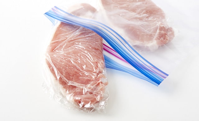 豚厚切り肉を冷凍用保存袋に入れている写真