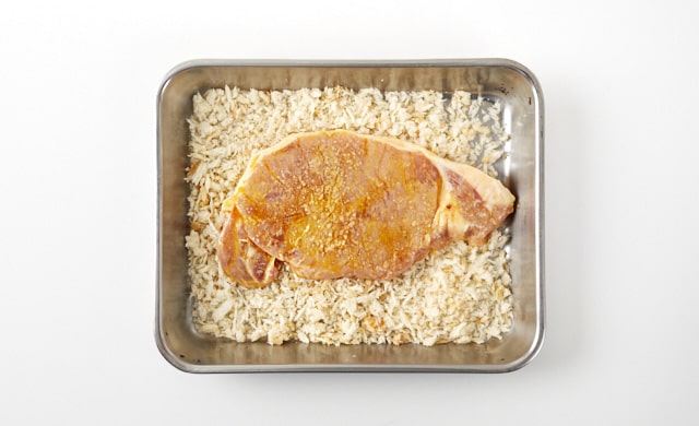 豚肉に衣をつけている写真