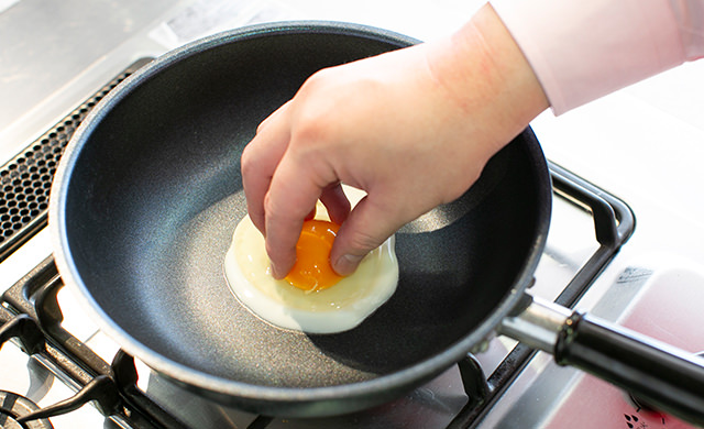 フライパンで目玉焼きを作っている様子