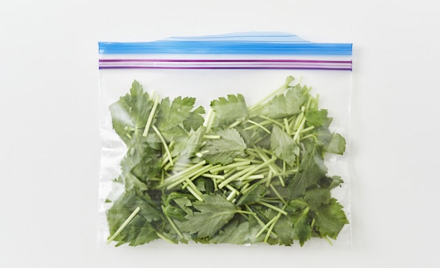 三つ葉を冷凍用保存袋に入れている写真
