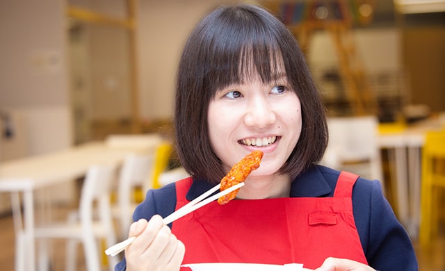 旨辛チキンを食べるニチレイフーズ中澤さん