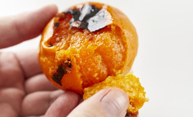 焼きみかんの皮をむいている写真