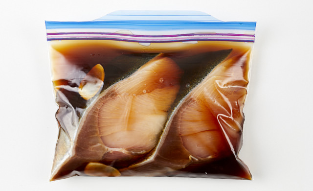 下味をつけたぶりを冷凍用保存袋に入れている写真