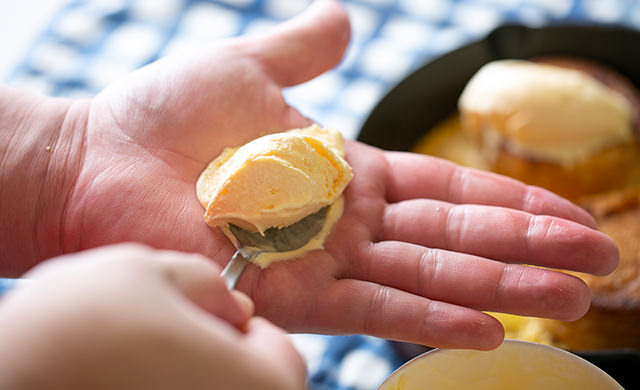 アイスを乗せたスプーンを手で温めている様子