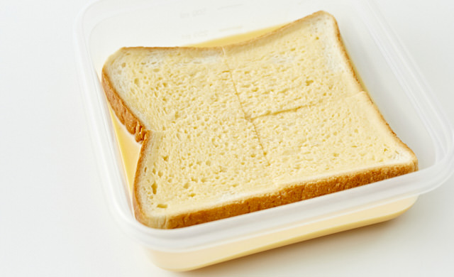 凍ったままのパンを卵液に浸している写真