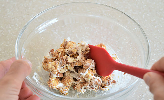 ボウルでポップコーンとマシュマロを混ぜている画像