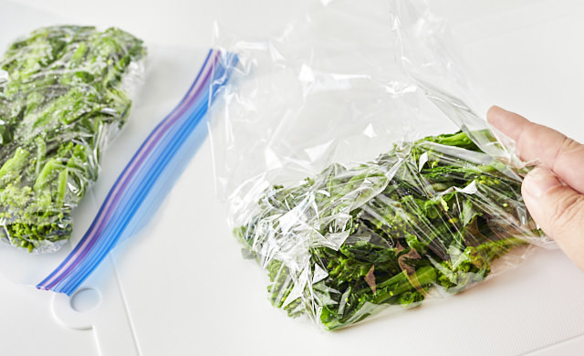 菜の花をラップに包む写真