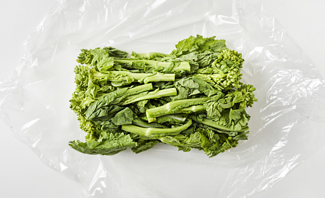 ラップに菜の花を包む写真