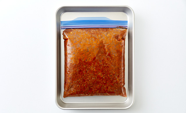 保存袋に入ったミートソースをバットにのせている写真