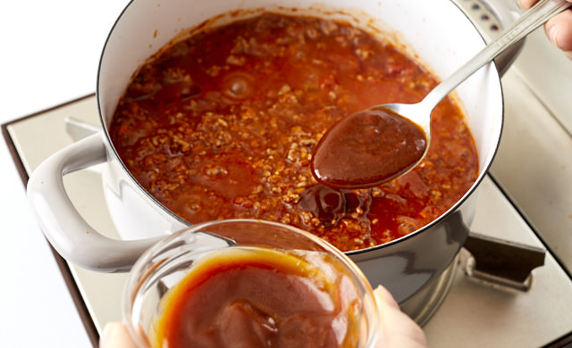 ミートソースにデミグラスソースを加えている写真