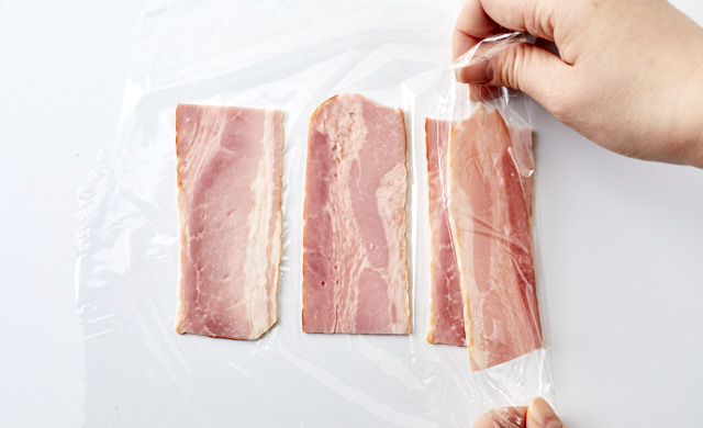 ラップに並べたベーコンを折りたたんでいる写真