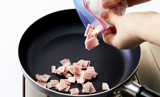 ベーコンをフライパンに入れている写真