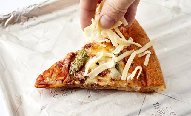 ピザにチーズをのせている写真