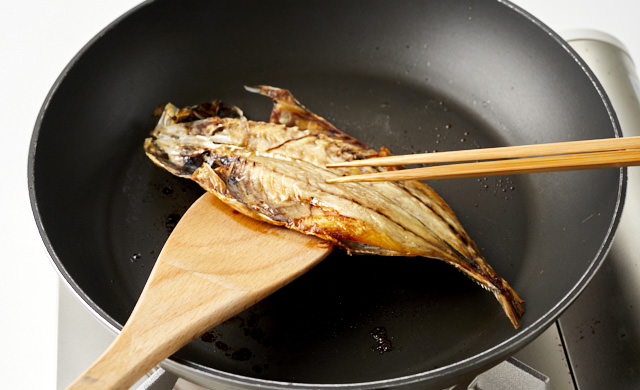 焼き魚をひっくり返している写真