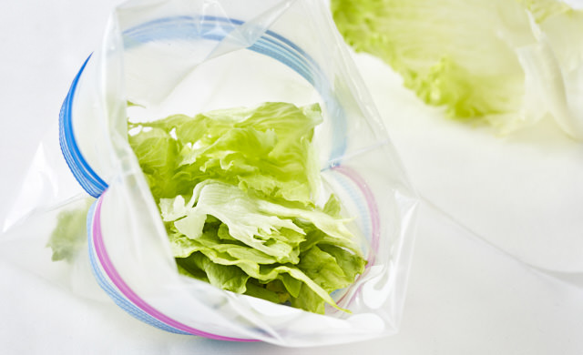 冷凍用保存袋にレタスを入れている写真