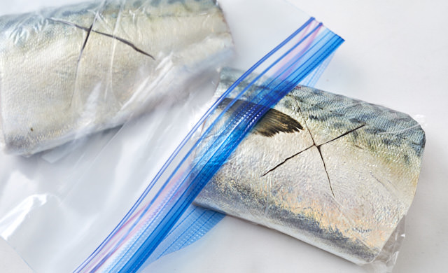 冷凍用保存袋にラップで包んだ鯖を入れている写真